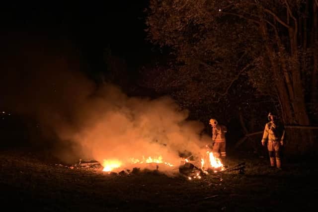 Firefighters extinguish a bonfire.