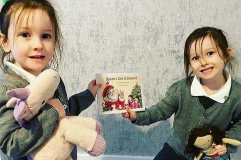 Isla Vincent and Freya Vincent, four, feature on the front of Santa's Got It Covered along with their favourite toys, Uni the unicorn and Dolly.