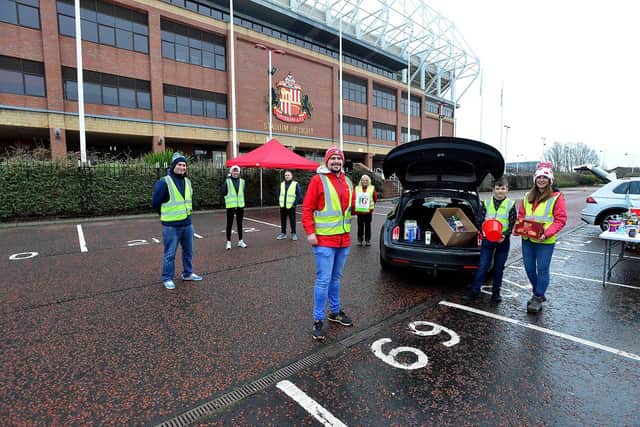 Front, left to right, Andrew Hird of Red and White Army, Jacob Brady (volunteer) with his step-mum Sophie Ashcroft, of the Foundation of Light, as they load a car with donated food as fellow volunteers look on.  Picture by Frank Reid.