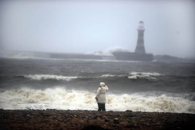 A walker braves the gusty conditions on Roker Beach earlier today.
