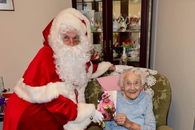 Santa Clause (Bob Hansford) delivers a 105th birthday card to Emma Patterson .  Picture by Frank Reid