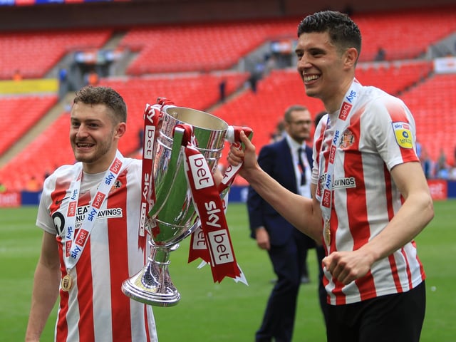 The two winning goal scorers celebrate by lifting the trophy