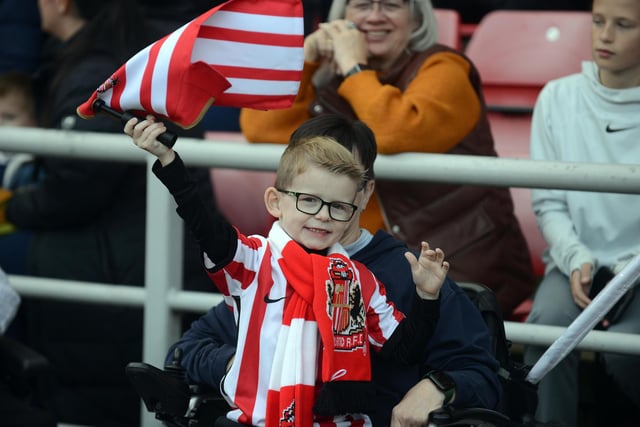 One young fan sporting Sunderland gear is captured waving a flag during the training session