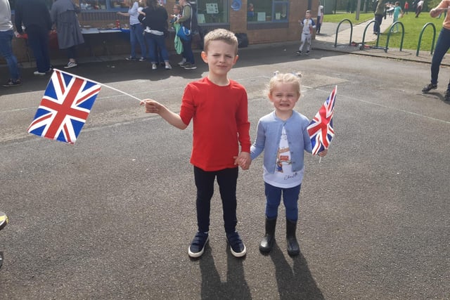Jude Hill, 6, and cousin Charlotte Cruicshanks, 4, wave Union Jack flags to show their support for King Charles III.