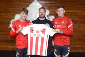 SAFC players Jack Clarke and Anthony Patterson holding the special edition Foundation of Light shirt alongside Great Annual Savings Group’s operations director Craig Shields.