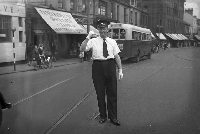 A police officer on duty in the days when there were trams and cars to patrol.
