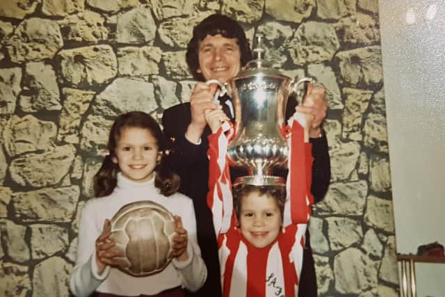 John and his family with the FA Cup in their home.