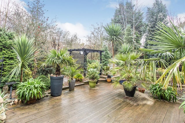 To the rear of the property, there is a secluded private garden with beautiful landscaped patios and plants.