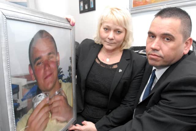 Trevor and Maria Burden with a photo of their son Jason, who died in an industrial accident when he was 19.