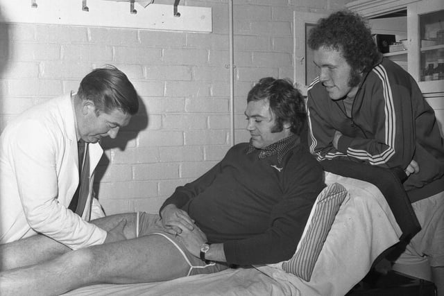 Mick McGovern, recovering from a cartilage operation, looks on as Sunderland's physiotherapist, John Watters, gives Ron Guthrie treatment in 1973.
