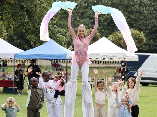 A stilt walker towers over young visitors.