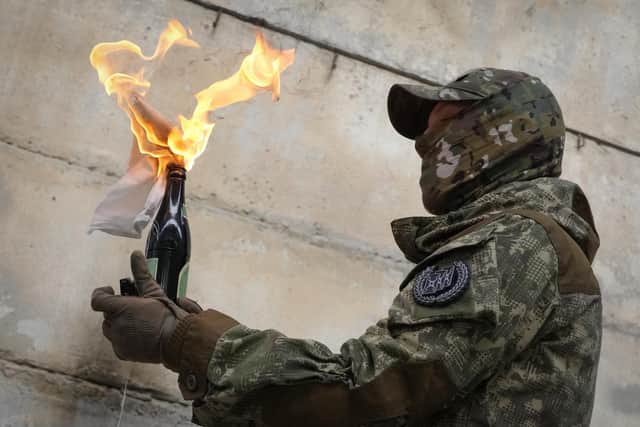 A local resident prepares to use a Molotov cocktail against a wall during an all-Ukrainian training campaign "Don't panic! Get ready!" close to Kyiv, Ukraine, Sunday, Feb. 6, 2022. (AP Photo/Efrem Lukatsky)