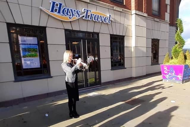 Fiona Taylor plays the Last Post outside Hays Travel's Gilbridge House office