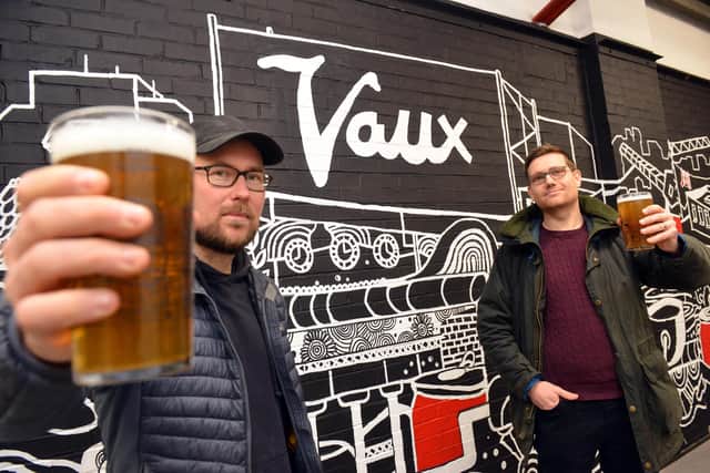 Vaux Brewery founders Steven Smith, left, and Michael Thompson toast the brewery's new Monk Street home in front of a giant mural.