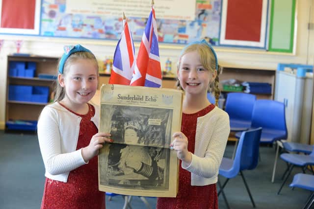 Twins Emily and Charlotte Palmer, nine, with a copy of the Sunderland Echo from the Coronation in June 1953.