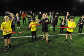 Kevin Ball has a helping hand from St Aidan's Catholic Academy pupils (left to right) Billy Robinson, Noah Taylor and Elliot Moon to officially open the 4G sports pitch at Ashbrooke Sports Centre, Sunderland as club officials and invited guests look. Picture by FRANK REID