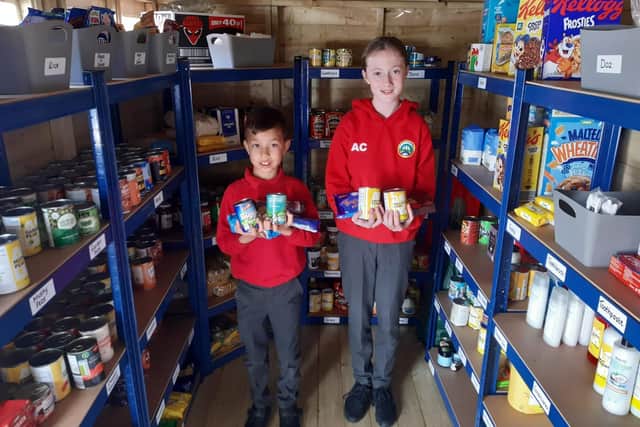 Year 6 pupils William Hartwell, 11, and Amelia Cooney, 11, in the school's new food bank.