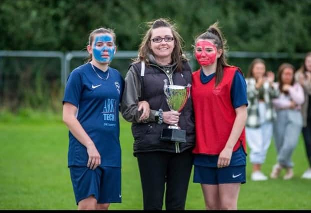 Christina Mole being presented with a trophy by her two daughters Olivia and Courtney at the Washington AFC 'Kick Cancer' event