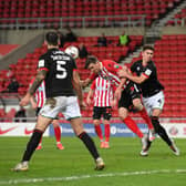 Charlie Wyke of Sunderland scores their side's first goal as he battles with Lewis Montsma of Lincoln City during the Papa John's Trophy semi-final match between Sunderland and Lincoln City.