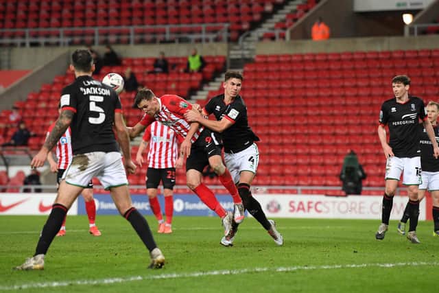 Charlie Wyke of Sunderland scores their side's first goal as he battles with Lewis Montsma of Lincoln City during the Papa John's Trophy semi-final match between Sunderland and Lincoln City.