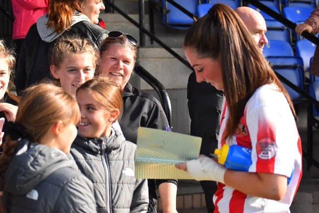 Neve Herron signs autographs for supporters