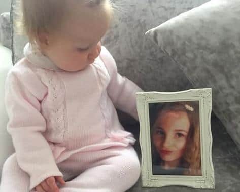 Josie Rae, now 10-months-old, with a photo of the aunt she never got to meet.
