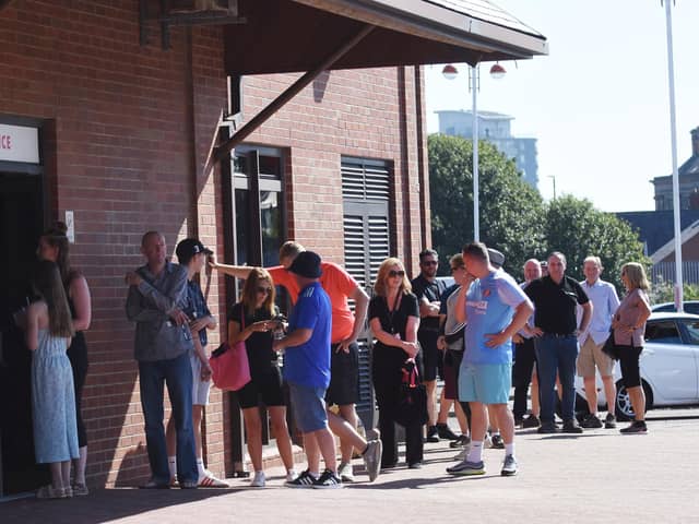Fans queuing in the sun