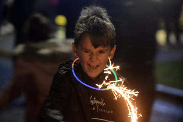 A youngster gets into the spirit of the season with a sparkler.
