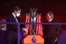 LIVERPOOL, ENGLAND - JULY 22: Richard Masters, Chief Executive of Premier League and Sir Kenny Dalglish, Former Captain and Manager of Liverpool place The Premier League trophy upon a plinth following the Premier League match between Liverpool FC and Chelsea FC at Anfield on July 22, 2020 in Liverpool, England.