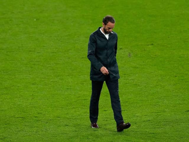 Gareth Southgate, Head Coach of England looks dejected as he walks across the pitch.