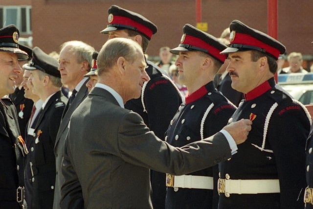 The Duke of Edinburgh admires the medals of firefighters at Sunderland station in May 1993.