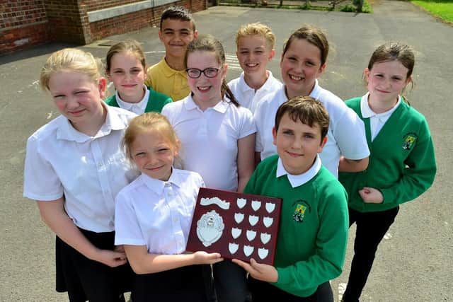 West Rainton Primary School pupils Kyla Riddell and Hamish Irving hold the Ray Bates "Love of Reading" shield as fellow pupils Jenny Wilson, Lilly Hindmarsh, Elizabeth Hall, Miley Neal, Chasry Lee, Evander Dickinson and Lola Irving look on. 

Picture by FRANK REID