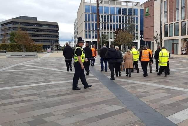 A group of police and council staff is allowed through the cordon
