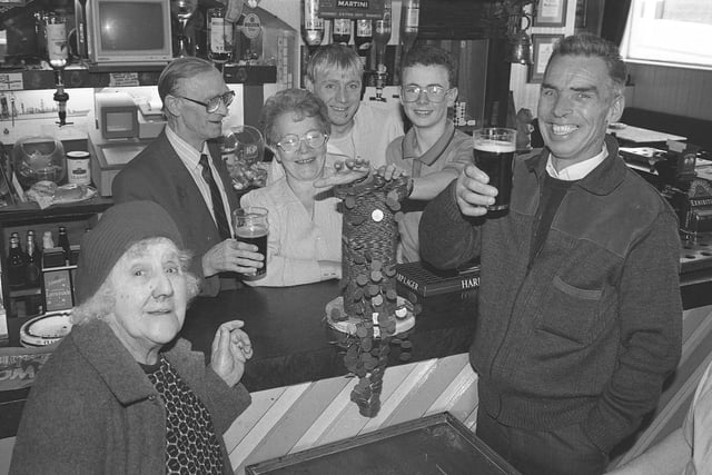 Boars Head landlady Catherine Bulmer gets a hand from grandson Lee Dunville to push over the £60 pile of pennies for the Echo Laser Appeal watched by John and Mark Clark, Elizabeth Drew and Ken Dunn. It's a flashback to 1991.