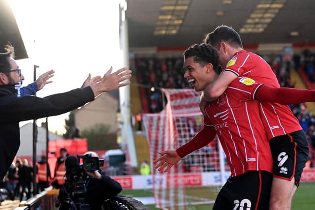 Brennan Johnson of Lincoln City celebrates after scoring their sides second goal with teammate Tom Hopper during the Sky Bet League One play-off semi-final first-leg match between Lincoln City and Sunderland.