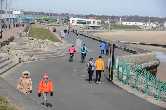 Walkers keep their distance on the promenade