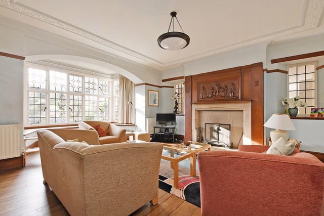 From the hallway, double doors open into the living room which has a beautiful stone feature fireplace with an open fire, a wooden surround and decorative engraved panel. There are two side facing windows and a bay window with garden views.