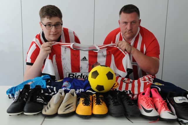 Michael McWilliams and Harvey's brother Luke with some of the donated football kit