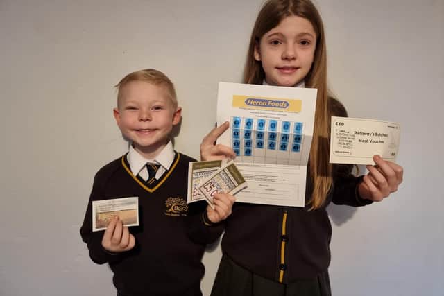 Bernard Gilpin Primary School pupils, Lewis, six, and Chloe, 10, with some of the food vouchers to help families over the festive season.
