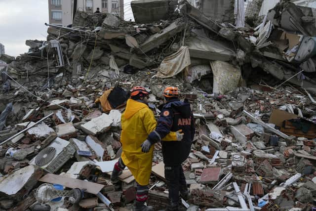 Emergency team members pause for a moment as they search for people in a destroyed building in Adana, the city in which Ahmet grew up and his father and siblings still live.  

AP Photo/Khalil Hamra