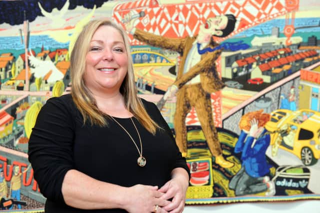 Exhibitions collections and archive manager Jo Cunningham in front of The Agony in the Car Park, one of the tapestries inspired by Grayson Perry's time in Sunderland