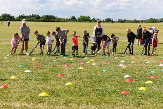Children taking part in a hockey dribbling exercise.