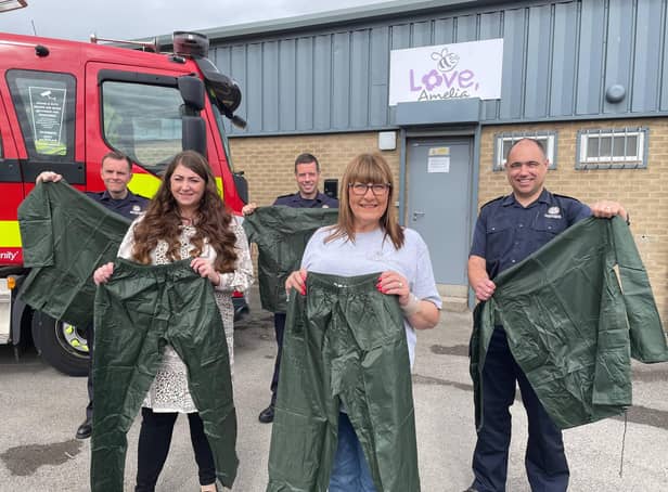 Steph Archbold and Gillian Pickles of Love, Amelia are pictured with Mark Stewart, Kyle Shaw and Andrew Lane of TWFRS outside of the charities offices holding examples of the donated waterproof clothing.