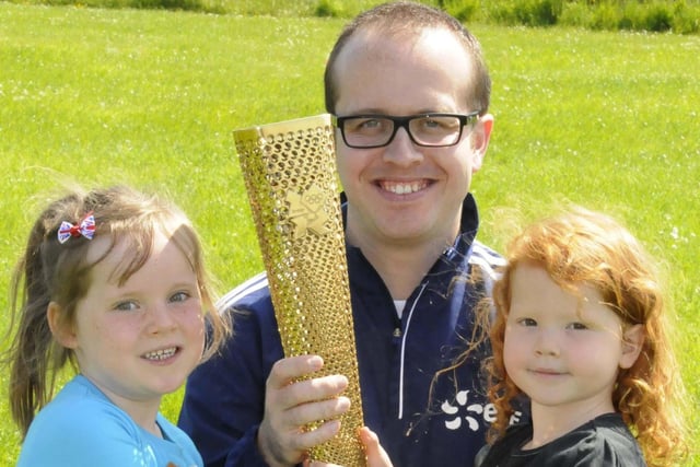 Lucie Willis and Anna Hope admire the Olympic Torch at Mill Hill Primary School. They were pictured with Gareth Capstick during the school sports day in 2012.