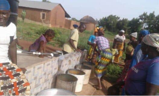 Queuing for water at a new borehole installed by Lynne's charity