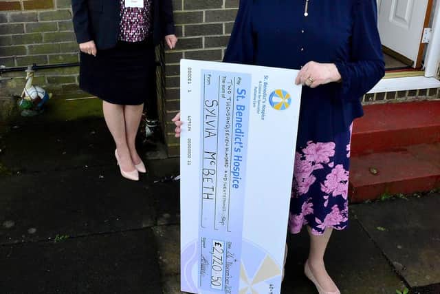 Sylvia McBeth (right) presents a cheque to her daughter Alison Keerie from St Benedict's Hospice. Sylvia hand made and sold face masks to raise funds for the hospice. Picture by FRANK REID