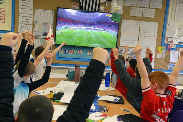 Hasting Hill Academy pupils show their support ahead of the match between England and Iran.