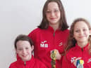 (Left to right) Sisters Molly Bowe, 8,  Marley Bowe, 13, and Macey Bowe, 10, with their 17 medal haul from two swimming competitions.