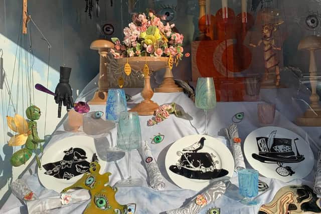 Ebony's pigeon plate design and Scarlett's cloud backdrop on display at Fortnum and Mason shop window in London.