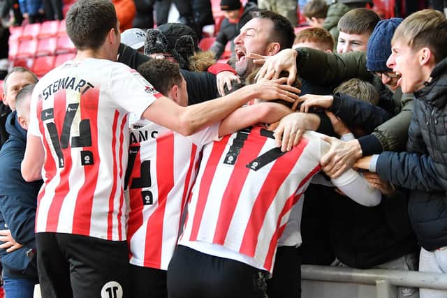 Sunderland players and fans celebrate Nathan Broadhead's late goal against Gillingham